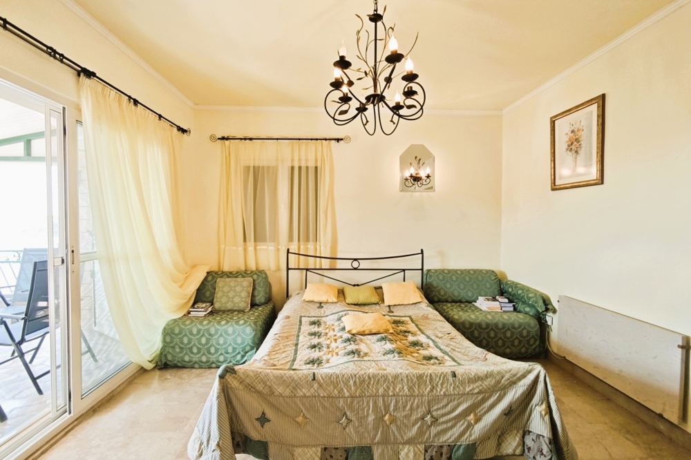 Schlafzimmer mit Doppelbett und Zugang zum Balkon