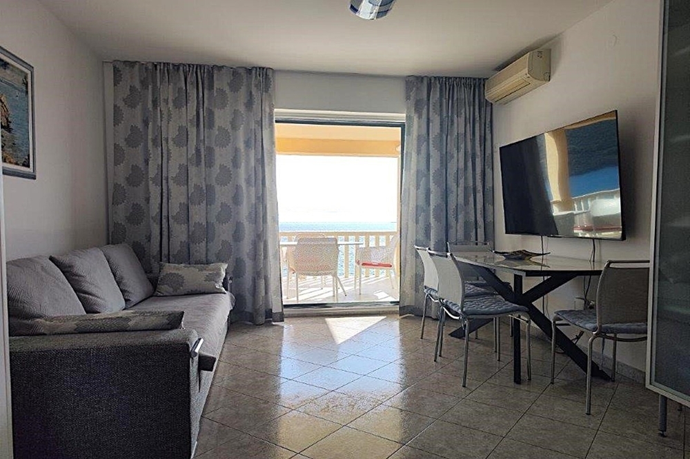 Wohnzimmer mit Zugang zum Balkon und Meerblick