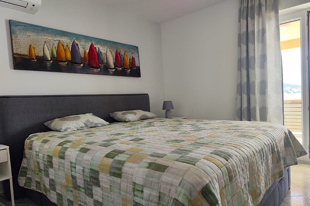 Schlafzimmer mit Balkonzugang und Meerblick