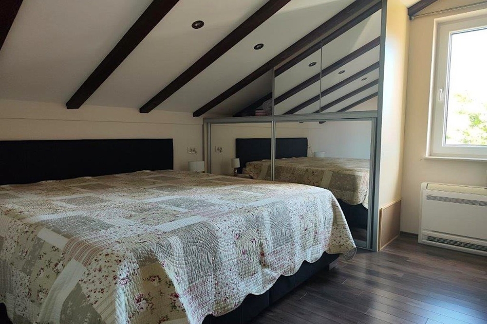 Schlafzimmer im Dachgeschoss mit sichtbaren Holzbalken