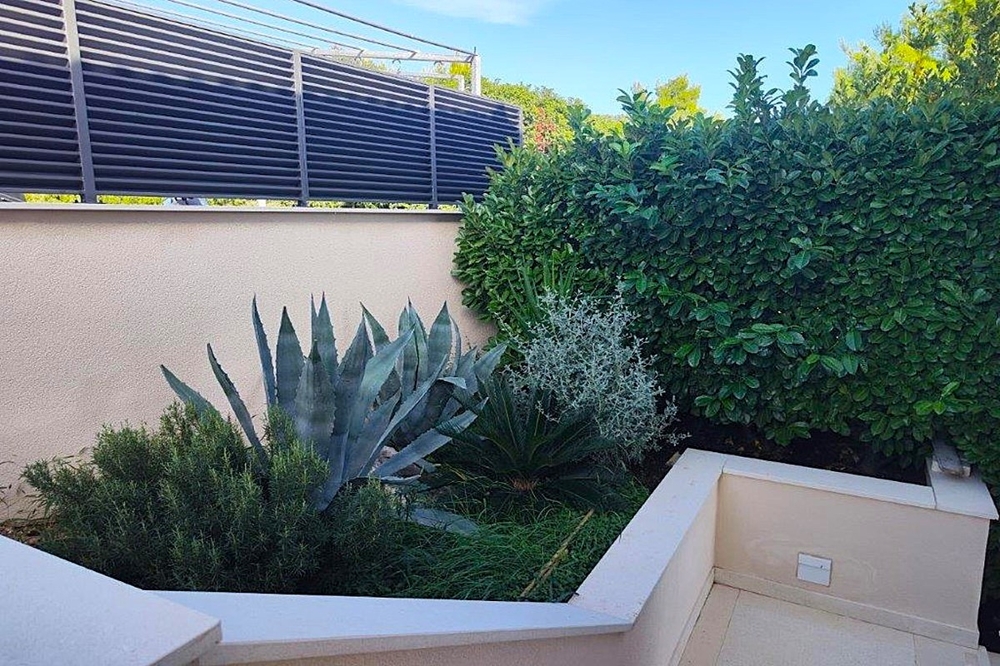 Gartenbereich mit mediterraner Bepflanzung und Steinmauern