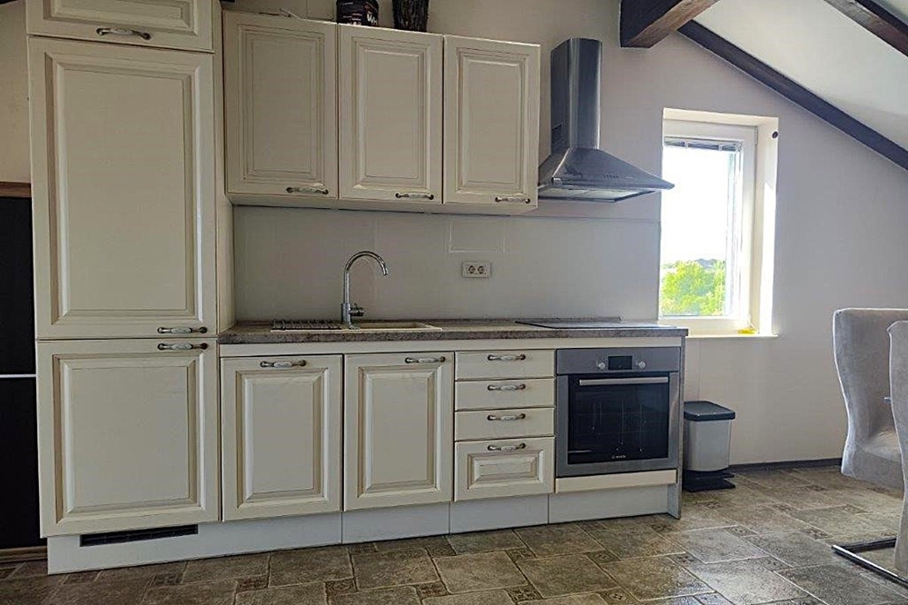 Küche mit Einbaugeräten und Dachschrägen