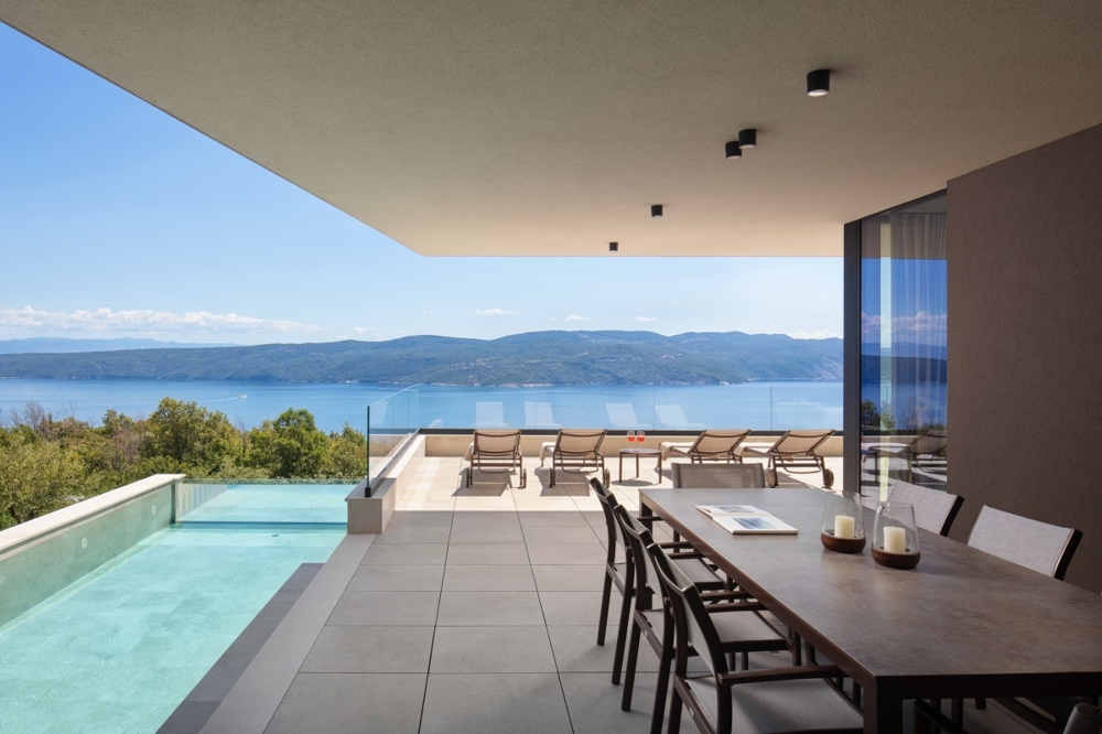 Überdachte Terrasse mit Essbereich und Meerblick