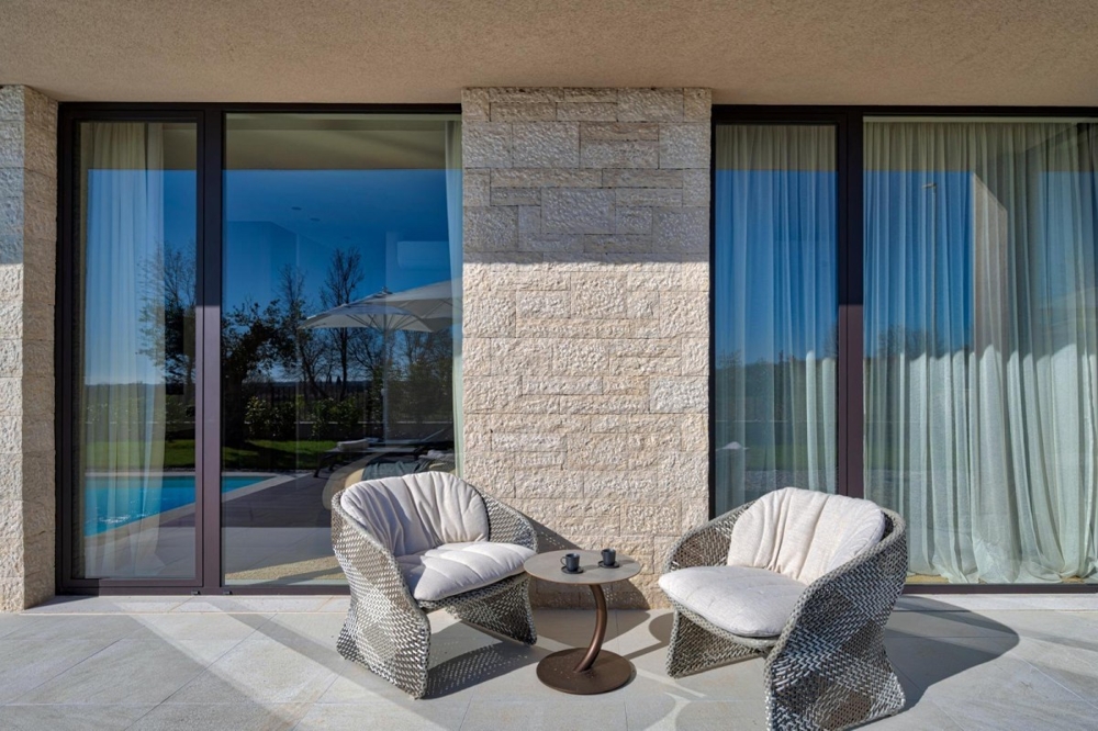 Überdachte Terrasse mit Sitzbereich und Glasschiebetüren