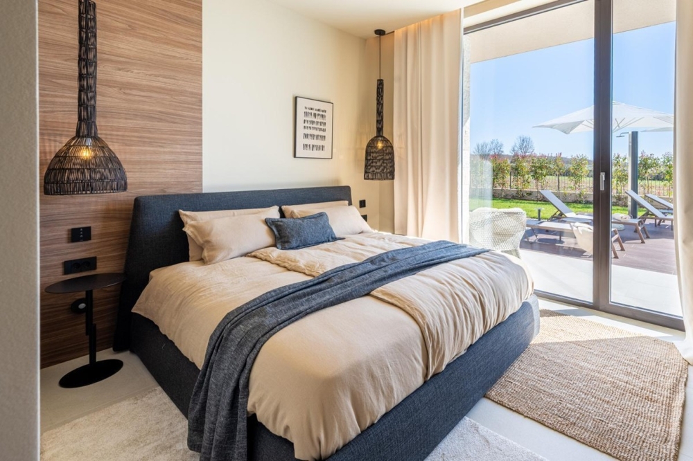 Schlafzimmer mit Zugang zur Terrasse und Poolblick