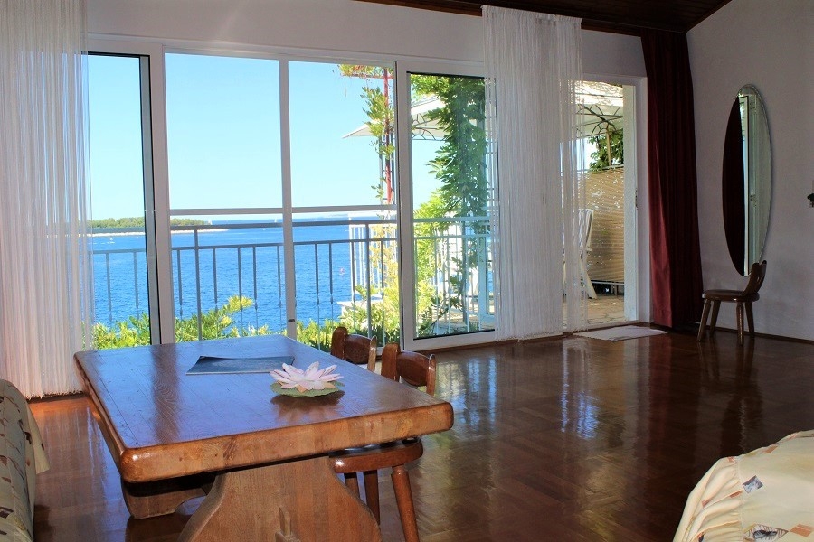 Wohnbereich mit großen Fensterfronten und Zugang zur Terrasse mit Meerblick