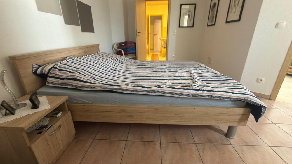 Schlafzimmer mit Doppelbett und Zugang zum Flur