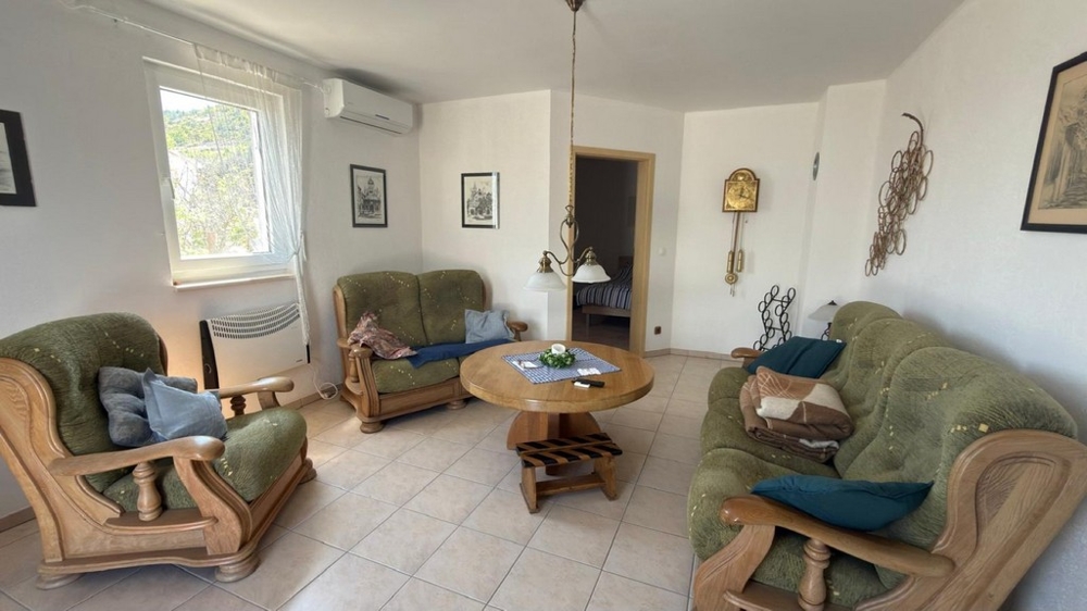 Wohnzimmer mit Sitzgruppe und Zugang zum Schlafzimmer