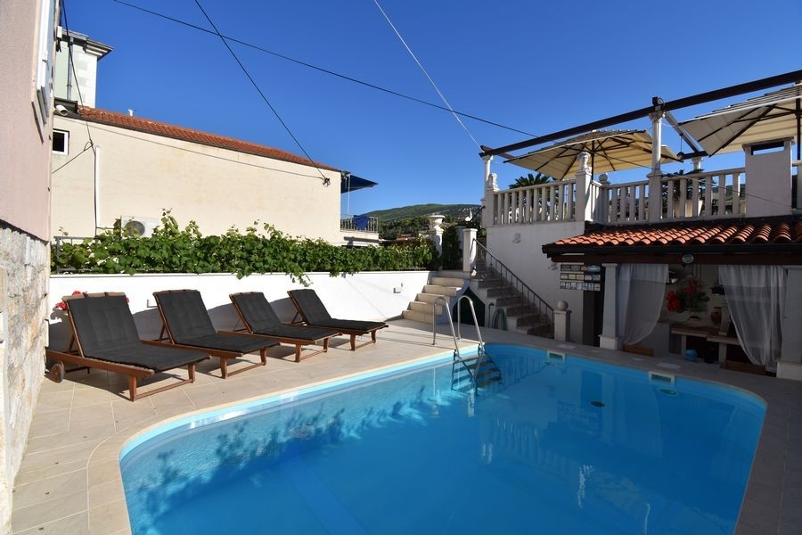 Pool mit Sonnenterrasse und Liegen