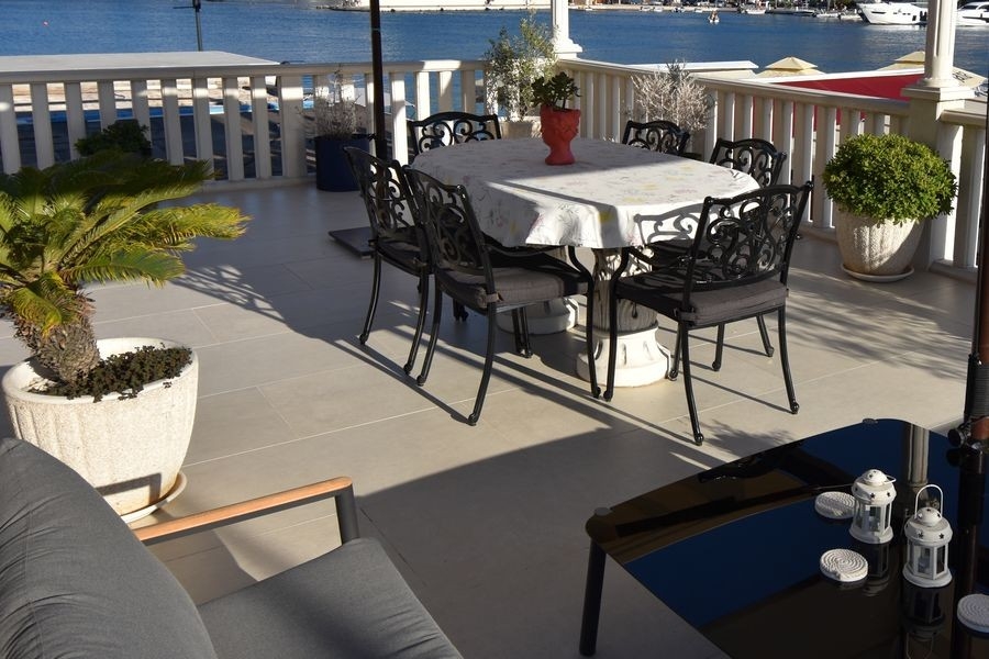 Überdachte Terrasse mit Sitzbereich am Wasser