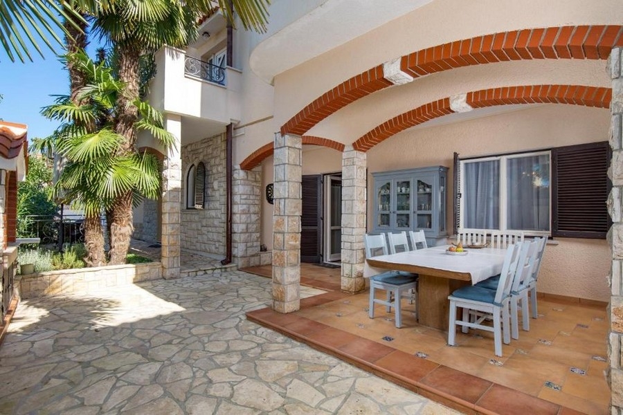 Überdachte Terrasse mit Sitzgruppe und Natursteinfassade