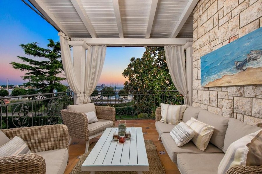 Balkon mit Lounge-Möbeln und Meerblick bei Sonnenuntergang