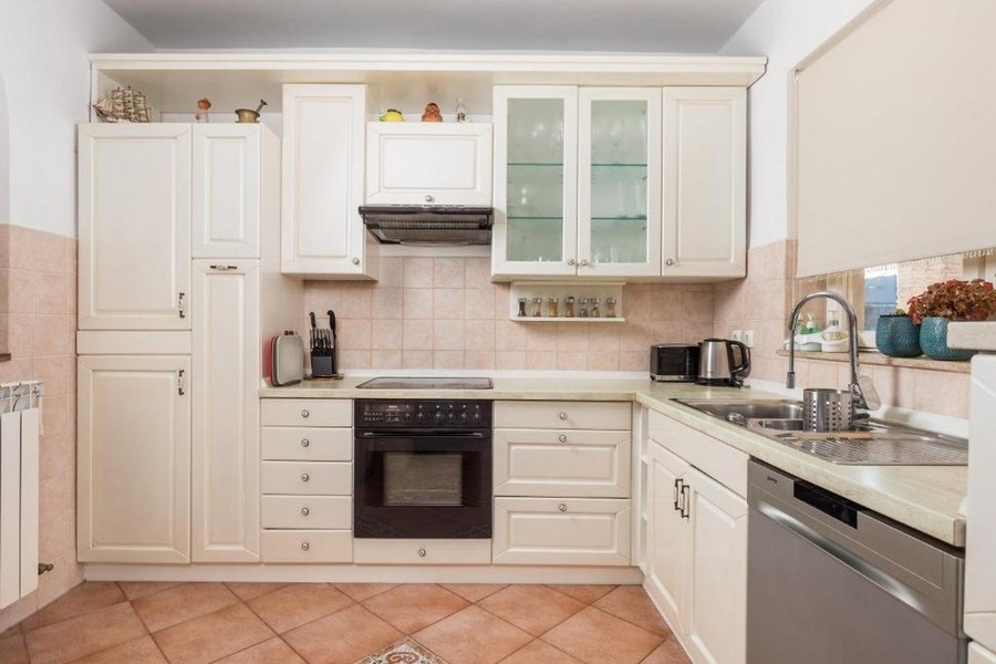 Küche mit Einbaugeräten und Arbeitsfläche