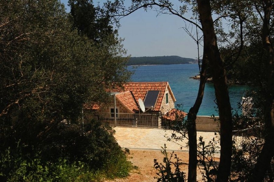 Steinhaus mit Meerblick zwischen Bäumen