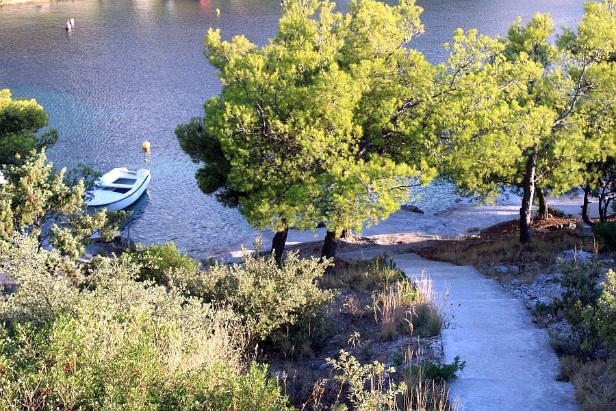 Weg zum Strand mit Boot in ruhiger Bucht