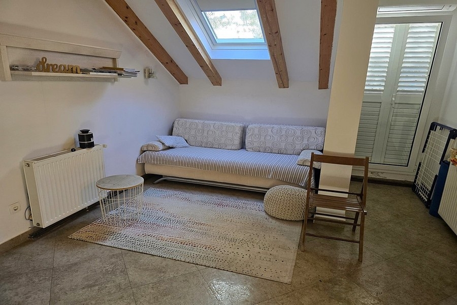 Wohnraum mit Sofa und Dachfenstern