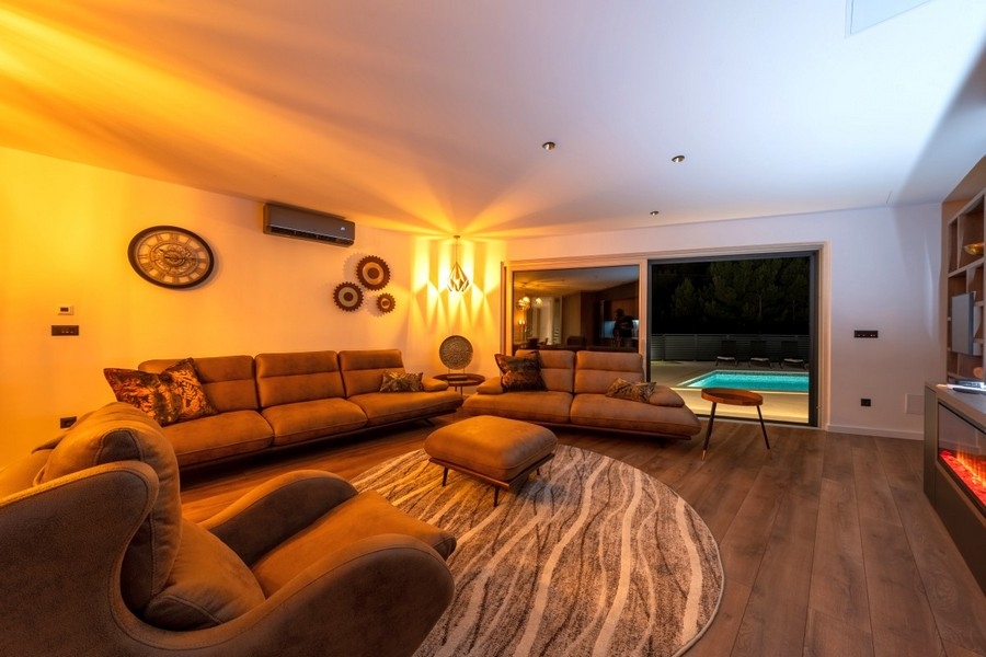 Wohnzimmer mit Zugang zur Terrasse und Poolblick