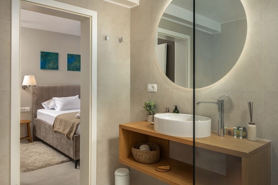 Badezimmer mit Waschbecken und Rundspiegel