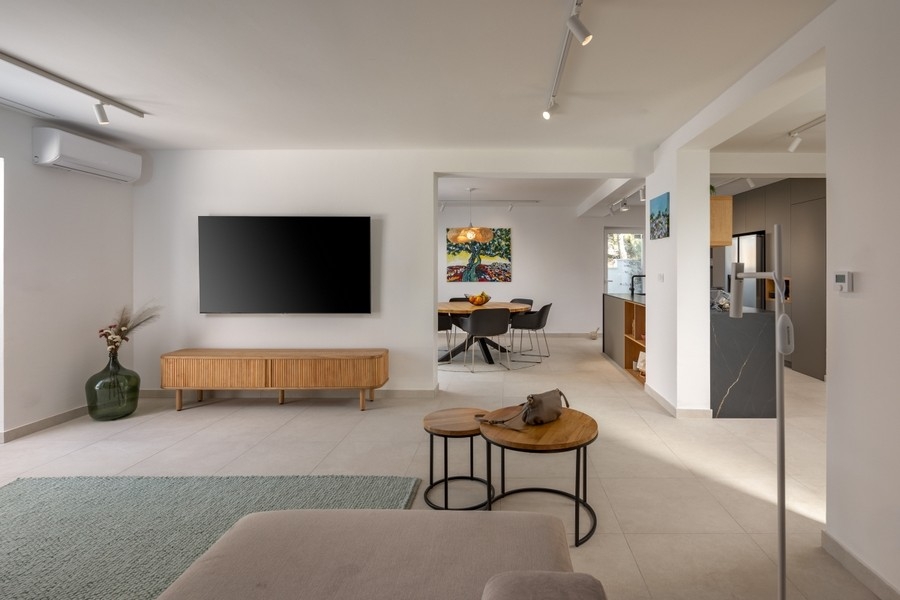 Offener Wohnbereich mit TV und Durchgang zur Küche