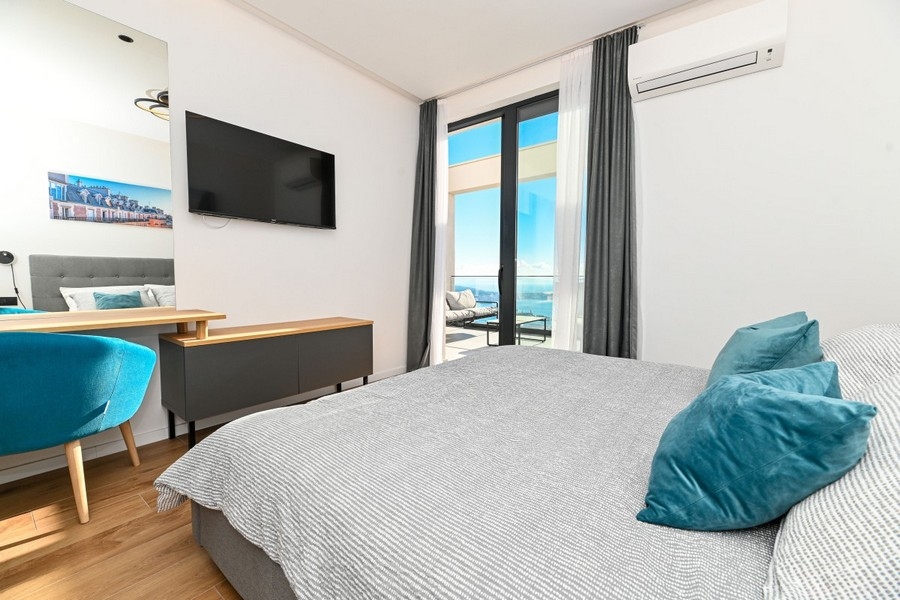 Schlafzimmer mit Zugang zur Terrasse und Meerblick