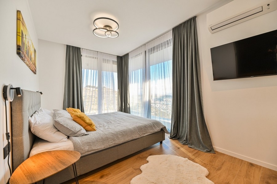 Schlafzimmer mit bodentiefen Fenstern und Ausblick