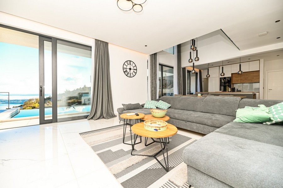 Wohnzimmer mit großen Fensterflächen und Poolblick