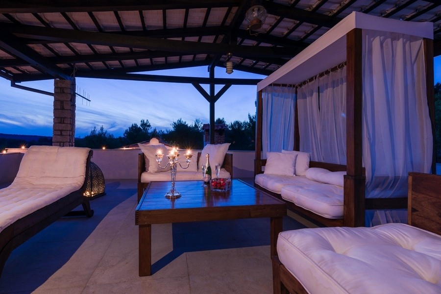 Loungebereich mit Himmelbett und Ausblick auf die Küste