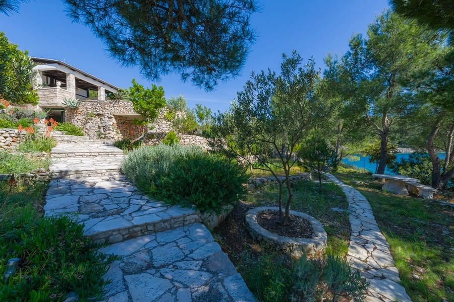 Natursteinterrasse mit Palmen und Küstenblick