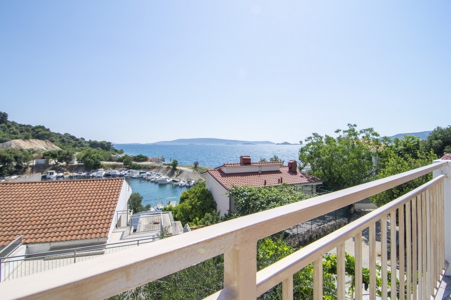 Gartenzugang mit mediterraner Bepflanzung und Blick auf das Meer