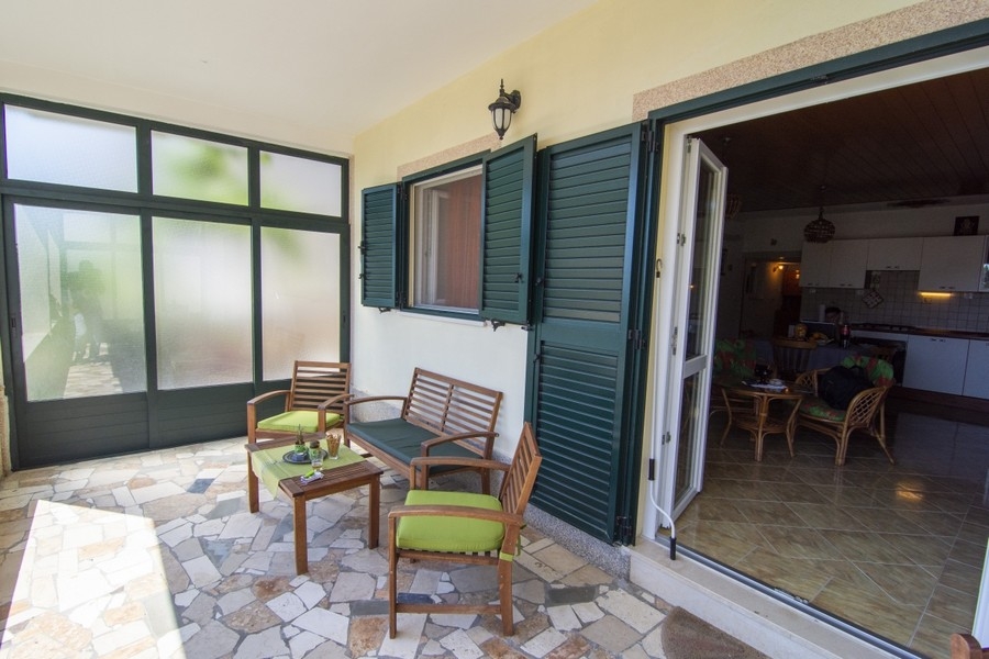 Überdachte Terrasse mit Sitzbereich und Zugang zum Wohnraum