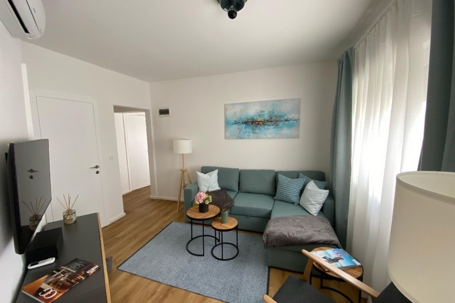 Wohnbereich mit Sofa und großen Fensterflächen