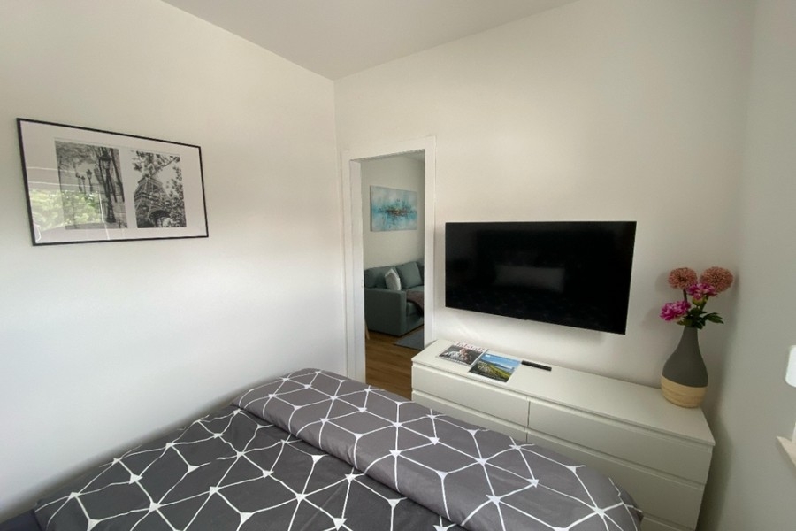 Schlafzimmer mit TV und moderner Einrichtung