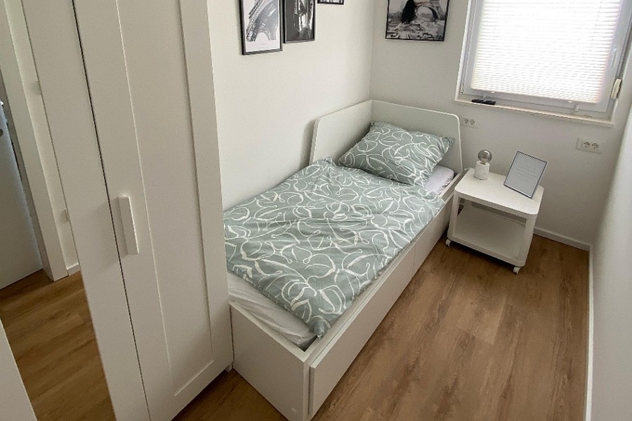 Kleines Schlafzimmer mit Einzelbett und Kleiderschrank
