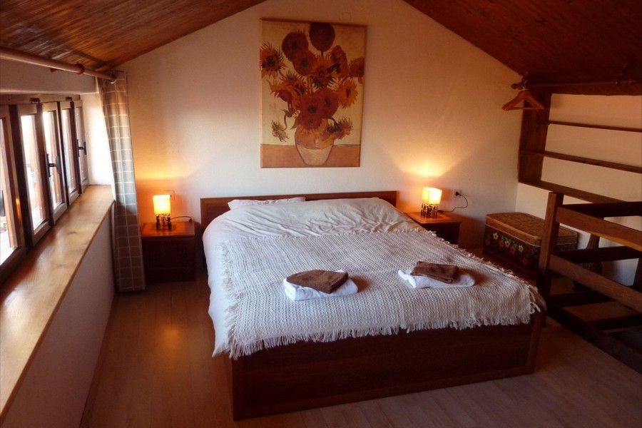Gemütliches Schlafzimmer im Dachgeschoss mit traditioneller Holzdecke