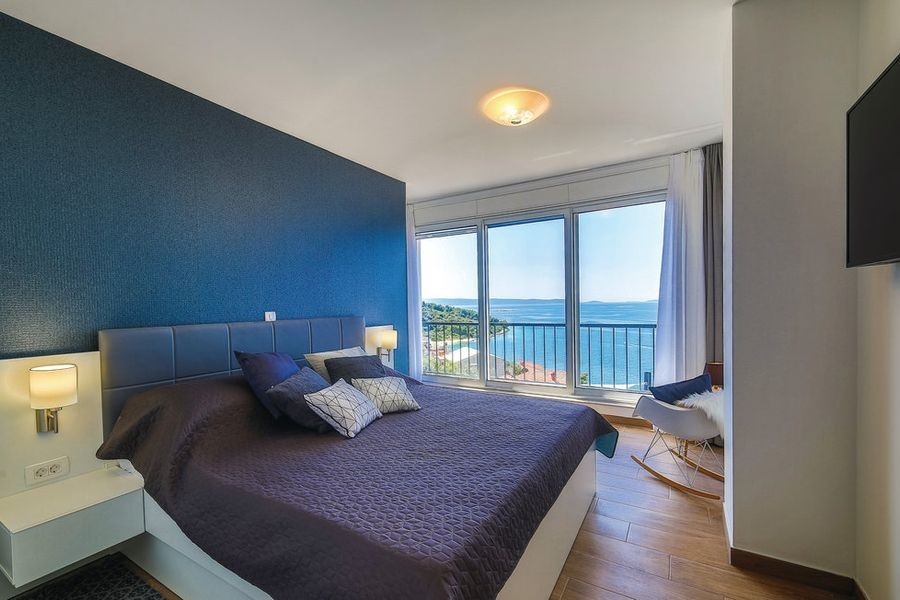 Schlafzimmer mit großflächigen Fenstern und Meerblick