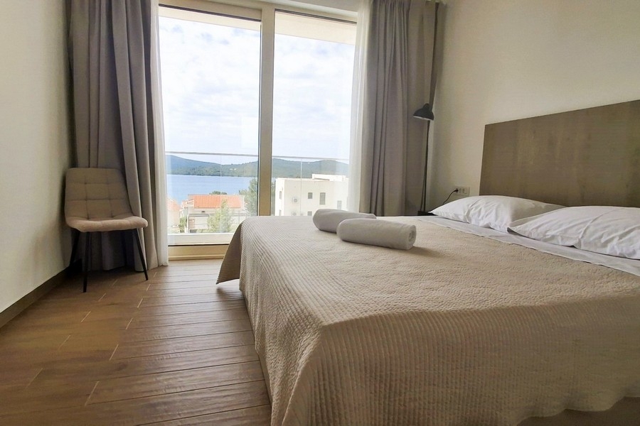 Schlafzimmer mit großem Fenster und Blick auf das Meer