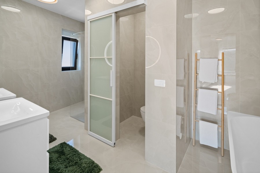 Modernes Badezimmer mit bodengleicher Dusche und Badewanne