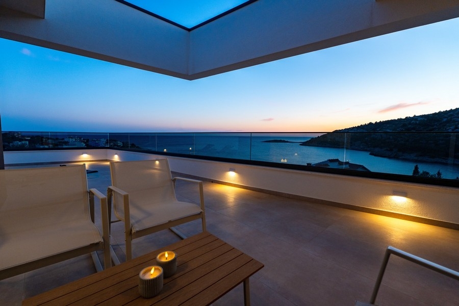 Überdachte Terrasse mit Panoramablick auf das Meer bei Abendstimmung