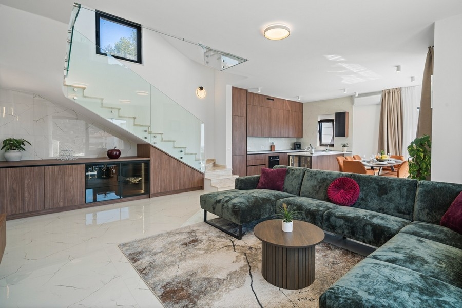 Moderner Wohnbereich mit offener Küche und Treppe in der Villa