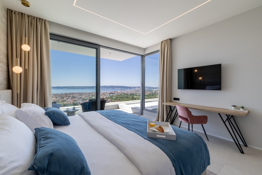 Modernes Schlafzimmer mit Glasfront und Küstenpanorama