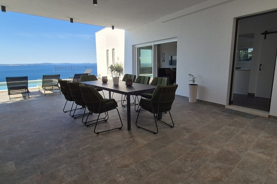 Großzügige Terrasse mit Pool und Loungebereich am Meer