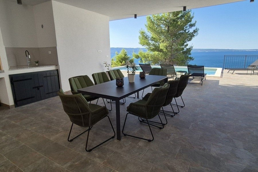 Überdachte Terrasse mit Außenküche und Blick aufs Meer