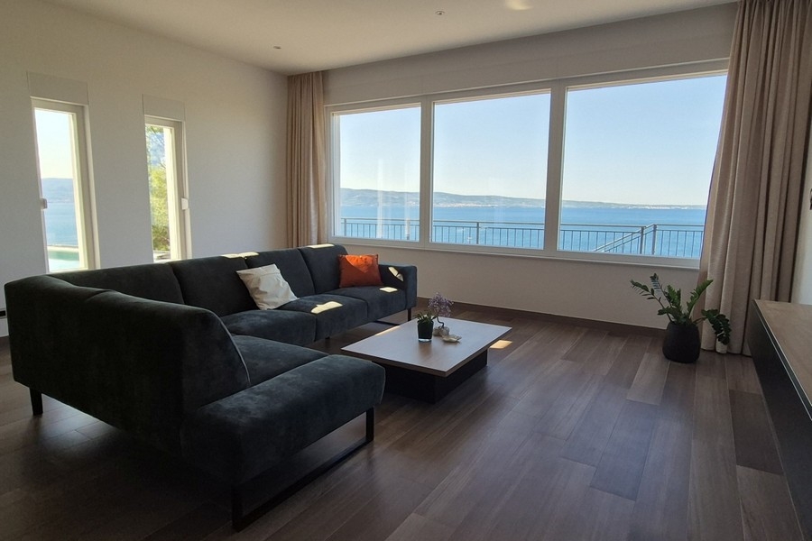 Wohnzimmer mit großer Fensterfront und Meerblick