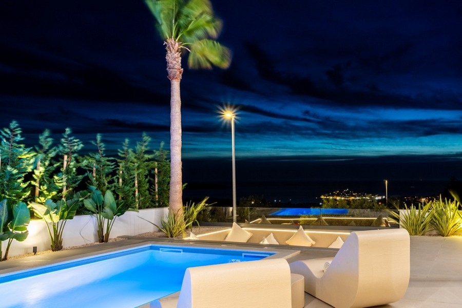 Beleuchteter Poolbereich bei Nacht mit Meerblick