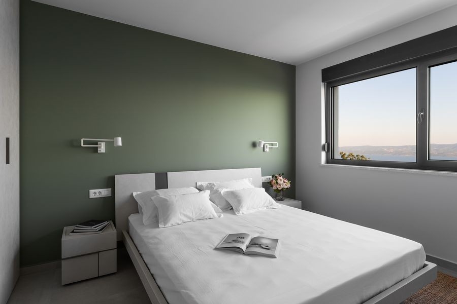 Helles Schlafzimmer mit großem Fenster und Meerblick