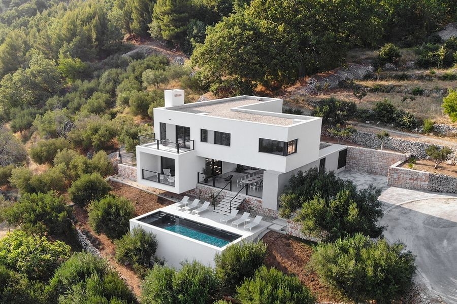Luftaufnahme einer modernen Villa mit Pool in Hanglage