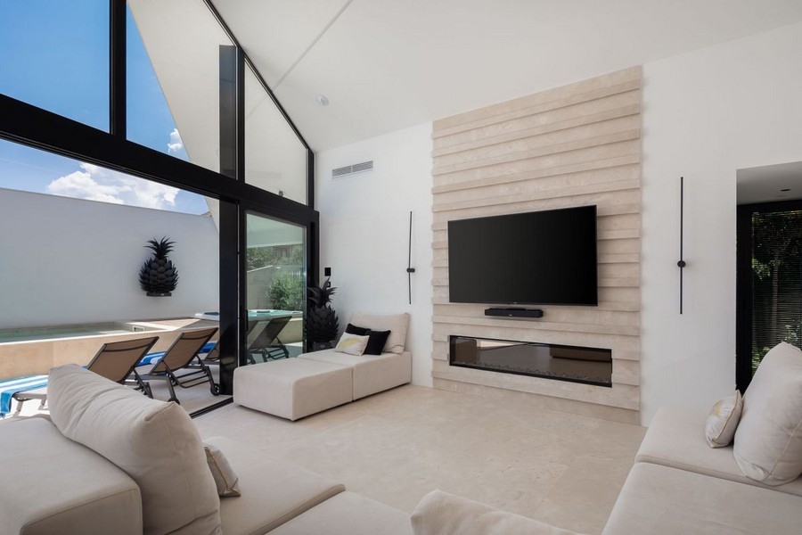 Wohnzimmer mit Fernseher und Terrassenzugang