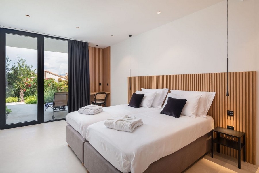 Schlafzimmer mit Holzwand und Gartenzugang