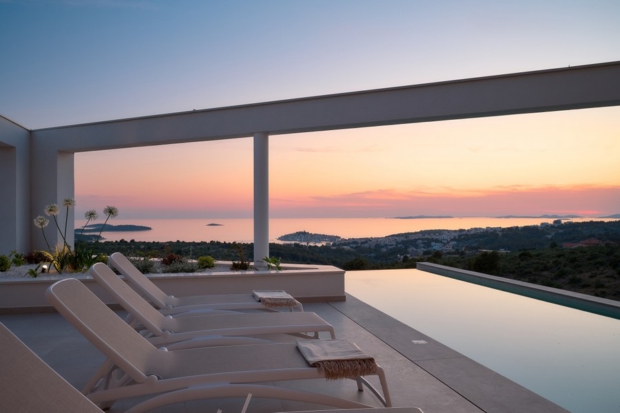 Terrasse mit Infinity-Pool und Meerblick bei Sonnenuntergang