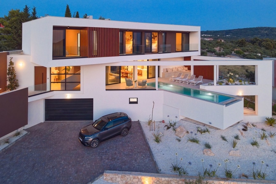 Beleuchtete Villa mit Pool am Abend